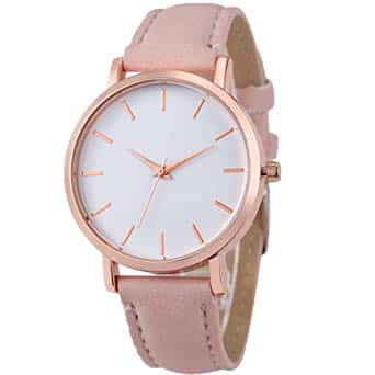 Cette image représente une montre élégante et luxueuse. Elle est en métal argenté, avec un cadran ovale et des chiffres romains à 12 heures. La couronne est ornée d'un diamant scintillant qui apporte une touche de sophistication supplémentaire à l'ensemble. Le bracelet en cuir noir ajoute encore plus d'élégance à cet accessoire précieux.